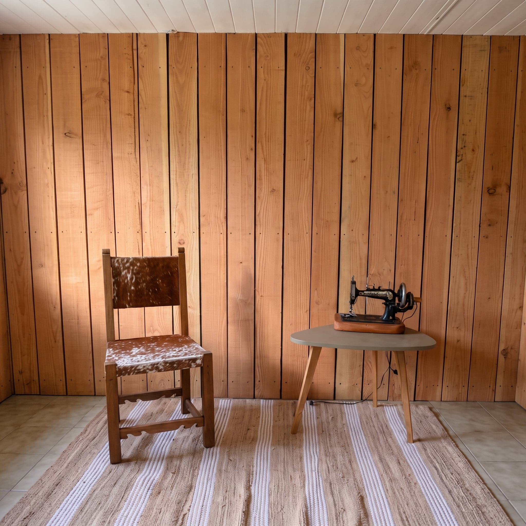 Pared de tablas de madera con una silla y una mesa